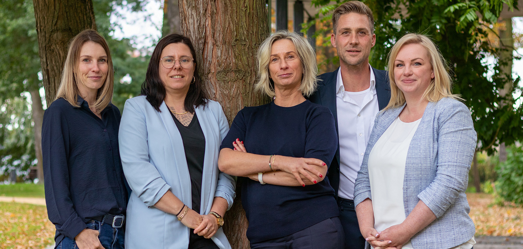 vent immobilien team steht um einen Baum